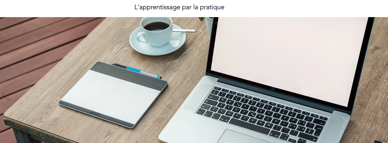 Ordinateur portable et tablette graphique posés sur un bureau en bois